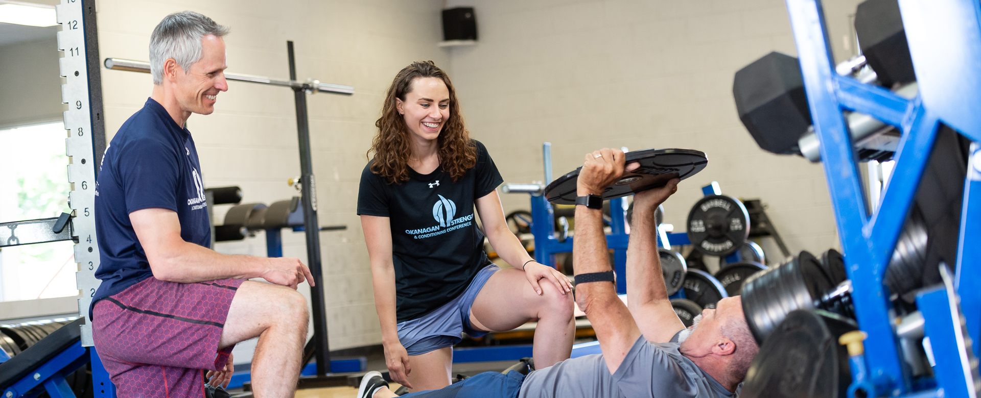 An employer and student in a gym working with a client.