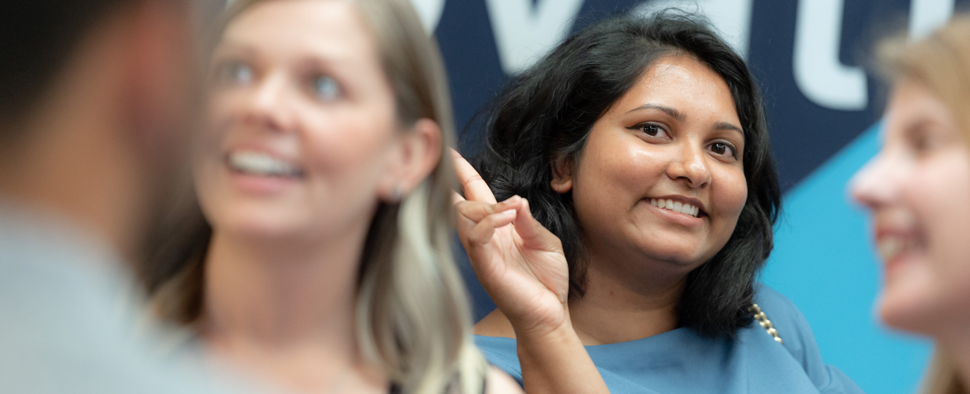 A student smiling at the camera through a crowd.